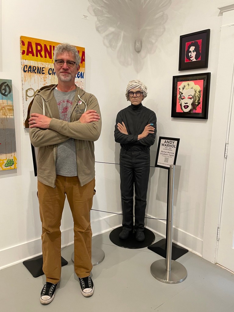 photo of Rob standing by a statue of Andy Warhol at Artemezia Foundation in Bisbee, AZ.